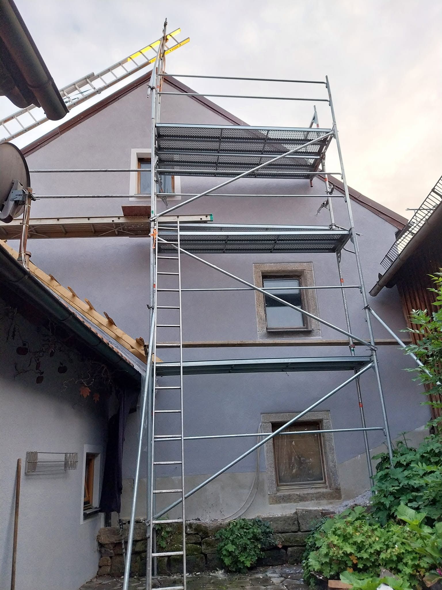 Hausgiebel mit Gerüst und Leiter in der Abendsonne