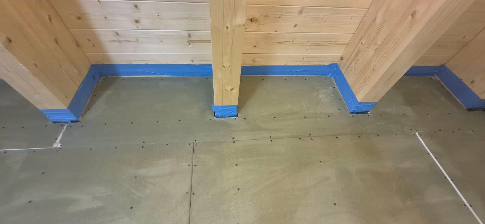 Plattenverkleidung zwischen sichtbaren Holzbalken an einer Decke im Innenausbau